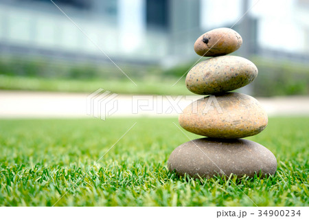stones stacked up on grass 34900234