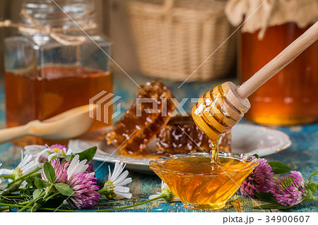 Two honey pots with honeycomb on a wooden tabl Two honey pots with honeycomb on a wooden tabl 34900607