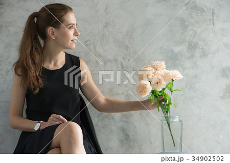 woman relaxing with flower in living room. 34902502