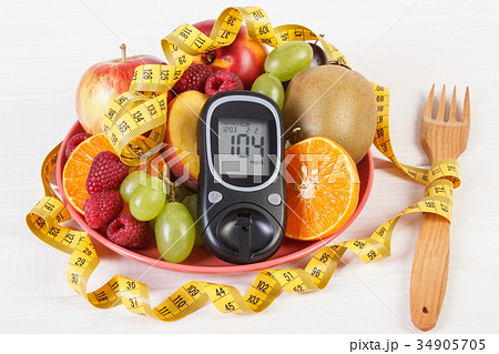 Glucometer, fresh fruits on plate and centimeter Glucometer, fresh fruits on plate and centimeter 34905705