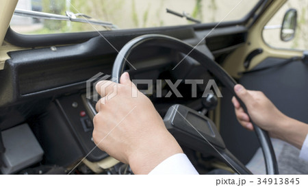 レトロ自動車を運転するビジネスマンのイメージカット レトロ自動車を運転するビジネスマンのイメージカット 34913845