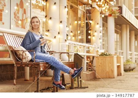 Cheerful woman in the street drinking morning 34917787