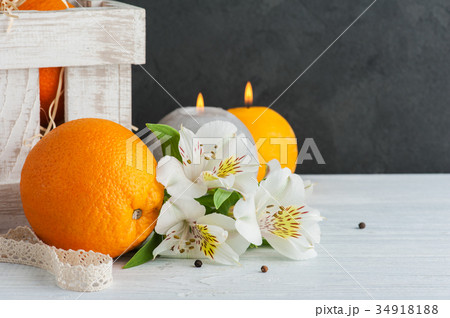 Oranges in wooden box, lit candles Oranges in wooden box, lit candles 34918188