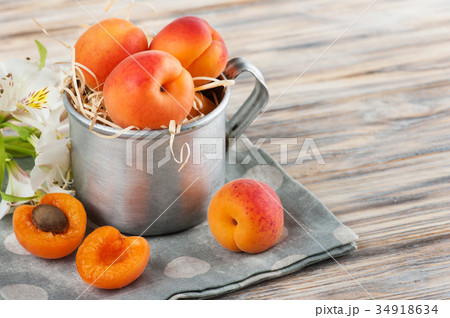 Closeup of fresh apricots in tin mug 34918634