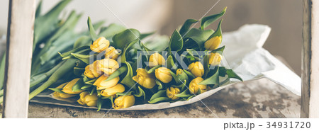Yellow tulips flowers bouquet on a wooden table Yellow tulips flowers bouquet on a wooden table 34931720
