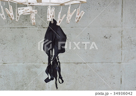 old black brassiere hanging on white clothespin  34936042