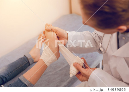 Serious young man dressing the wound 34939896