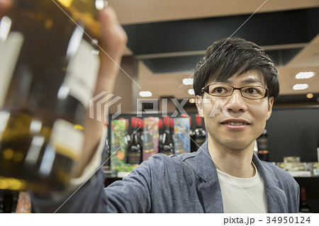 お酒売り場でワインを手に取る男性 34950124
