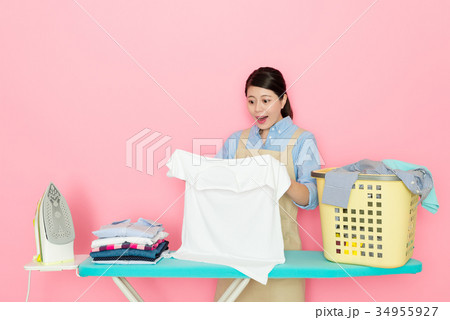female houseworker looking at white clothing female houseworker looking at white clothing 34955927