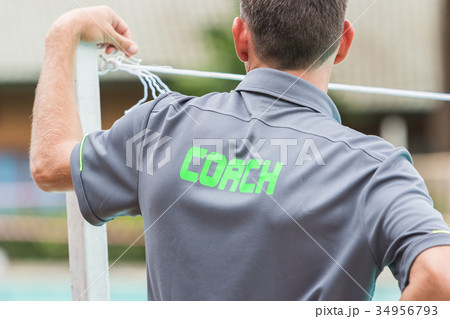 back of a coach's grey shirt with the word Coach 34956793