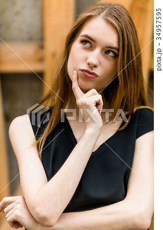 Beautiful young female dreaming outdoors. Beautiful young female dreaming outdoors. 34957595