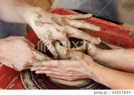 Hands of two people create pot, potter's wheel 34957844