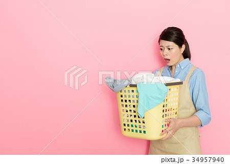 young female maid worker holding laundry basket 34957940