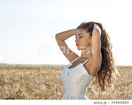 Beautiful summer girl in a wheat field, in a white 34960884