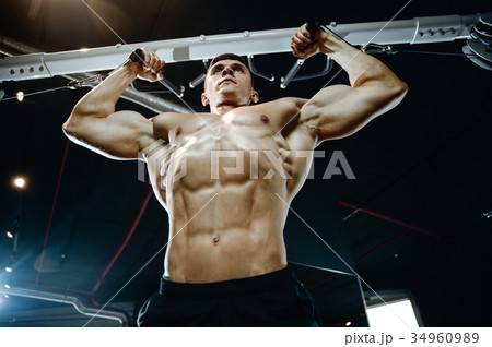 Handsome model young man training arms in gym Handsome model young man training arms in gym 34960989