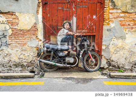 A boy sitting on an Old Motorcycle at George Town 34969438