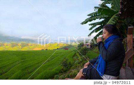 Woman tourism sitting on wood balcony drink coffee 34972011