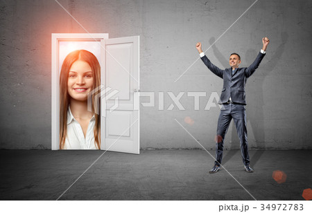 A happy businessman in victory motion stands in a 34972783