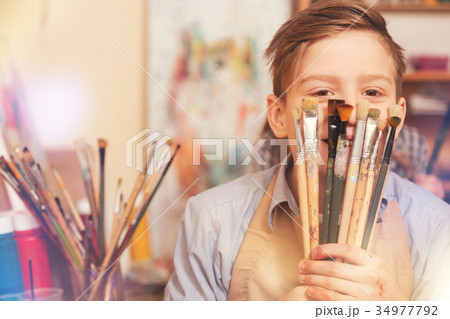 Funny teenage boy playing with brushes while Funny teenage boy playing with brushes while 34977792