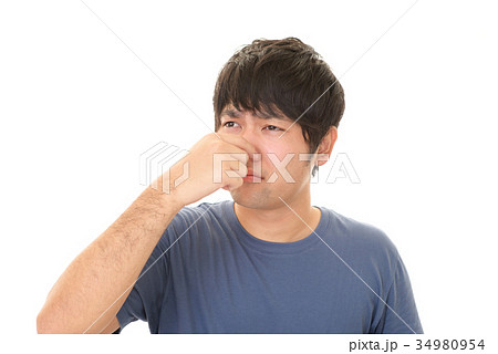 鼻をつまむ男性の写真素材