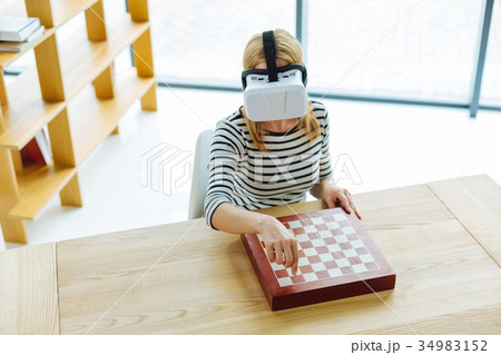 Smart nice woman playing virtual chess Smart nice woman playing virtual chess 34983152