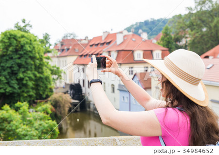 woman taking picture of Old Town in Prague with a 34984652