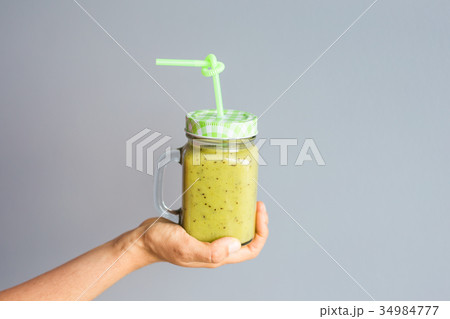 Healthy green smoothie in woman's hand. Vegan, raw 34984777