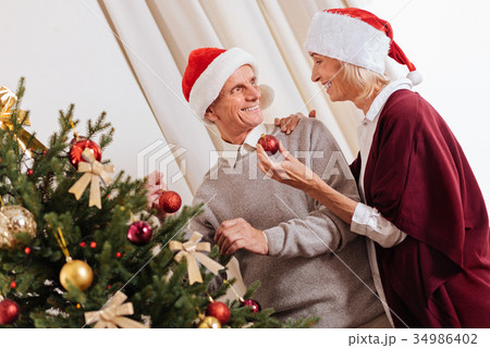 Delighted female person giving Christmas toy 34986402
