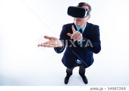 Delighted nice man looking at his palm Delighted nice man looking at his palm 34987268