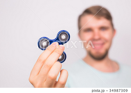 young man playing with a fidget spinner, focus on 34987309