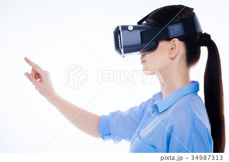 Pleasant young woman looking in front of her Pleasant young woman looking in front of her 34987313