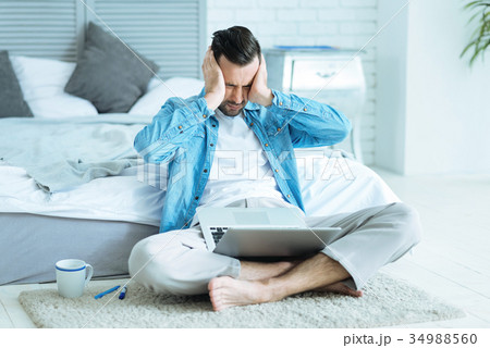 Exhausted self employed man pressing head while Exhausted self employed man pressing head while 34988560