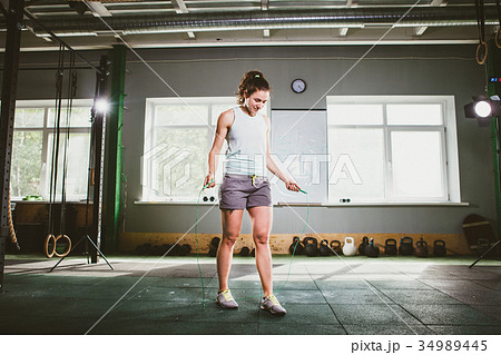 Young Caucasian smiling woman holding a skipping rope - Health and Fitness Concept Young Caucasian smiling woman holding a skipping rope - Health and Fitness Concept 34989445