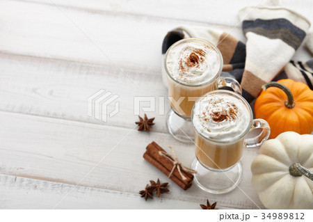 Fall pumpkin spice latte with whipped cream on white wooden background Fall pumpkin spice latte with whipped cream on white wooden background 34989812