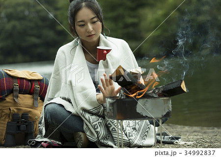 キャンプ 女性 一人旅 ソロキャンプ たき火の写真素材