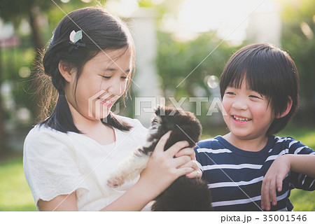 Asian children playing with siberian husky puppy 35001546