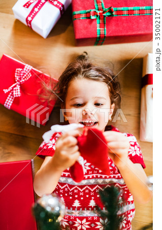 Little girl lying on the floor among presents. Little girl lying on the floor among presents. 35002171