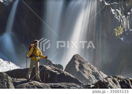 Backpacker looking at waterfall 35003133