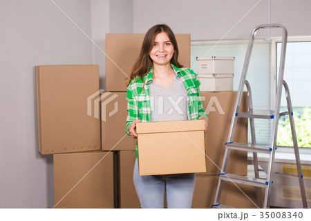 Portrait of woman carrying cardboard box in new Portrait of woman carrying cardboard box in new 35008340