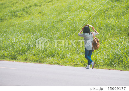 Asian traveler with backpack walking on road 35009177