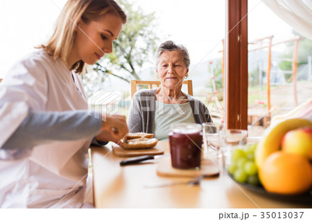Health visitor and a senior woman during home 35013037