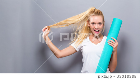 Woman holding yoga mat 35018588