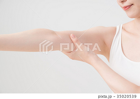 セルフマッサージをする女性 二の腕 腕の写真素材
