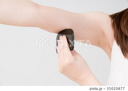 セルフマッサージをする女性 かっさ 二の腕の写真素材