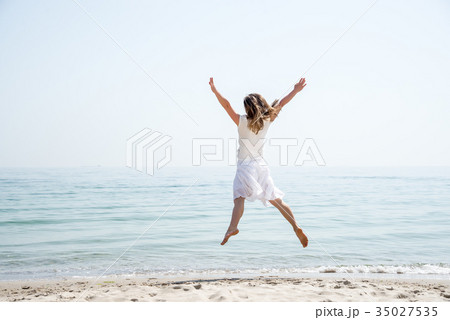 Happy beautiful young girl jumping Happy beautiful young girl jumping 35027535