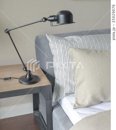 Gray and brown pillows on bed with foldable lamp Gray and brown pillows on bed with foldable lamp 35029076