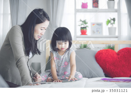 Happy asian family. Pregnant mother and baby daughter hug relaxi Happy asian family. Pregnant mother and baby daughter hug relaxi 35031121
