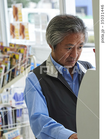 コンビニのATMを使う男性 35031446