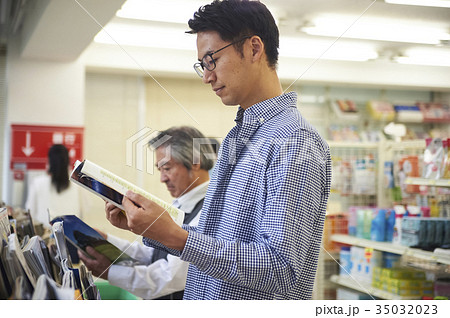 コンビニで立ち読みをする男性 35032023