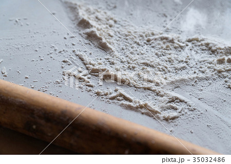 sifted flour on the table, a rolling pin 35032486